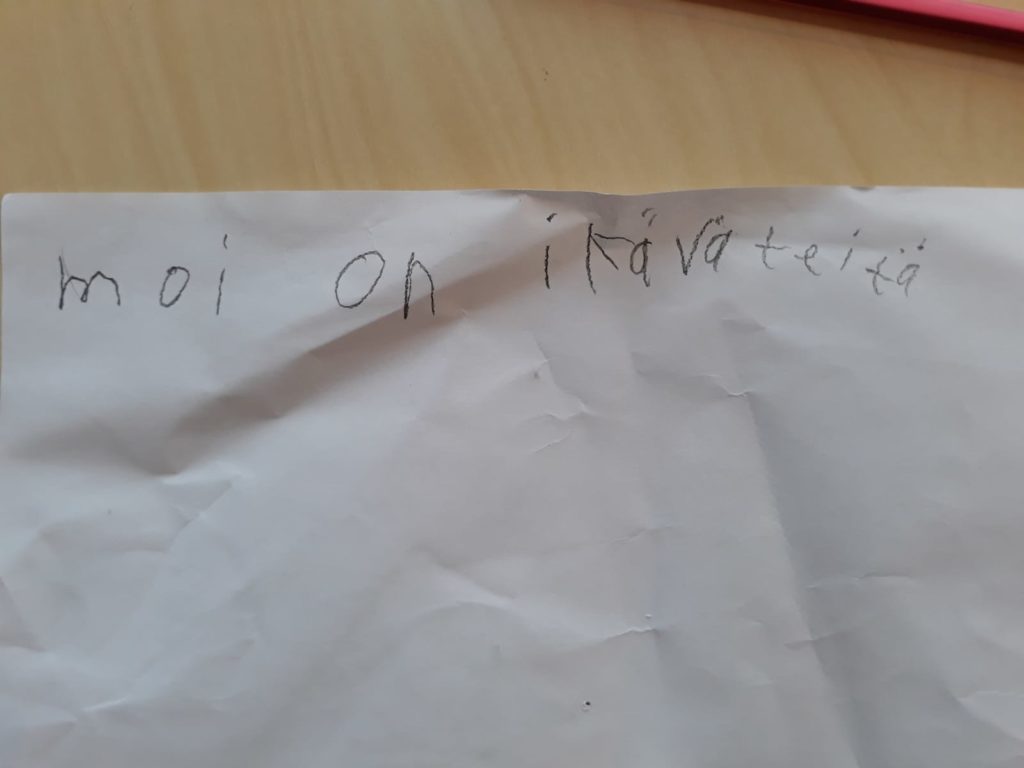 Käsinkirjoitettu lappu, jossa teksti "Moi on ikävä teitä.".