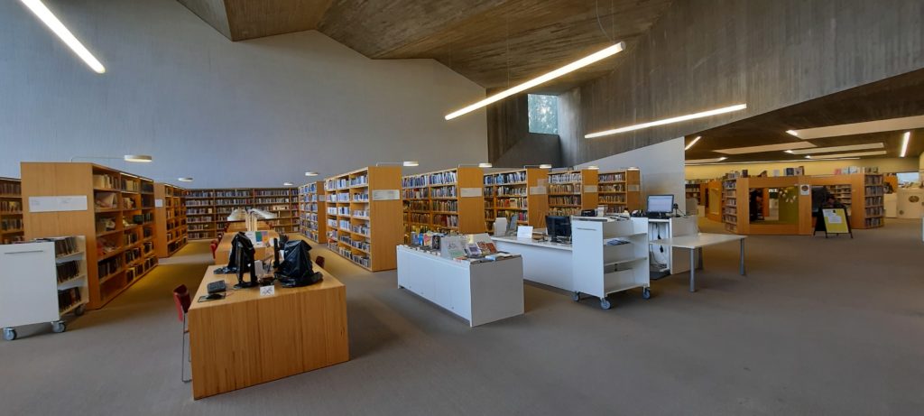 Bookshelvers, desks and the information desk of the Apila book hall.