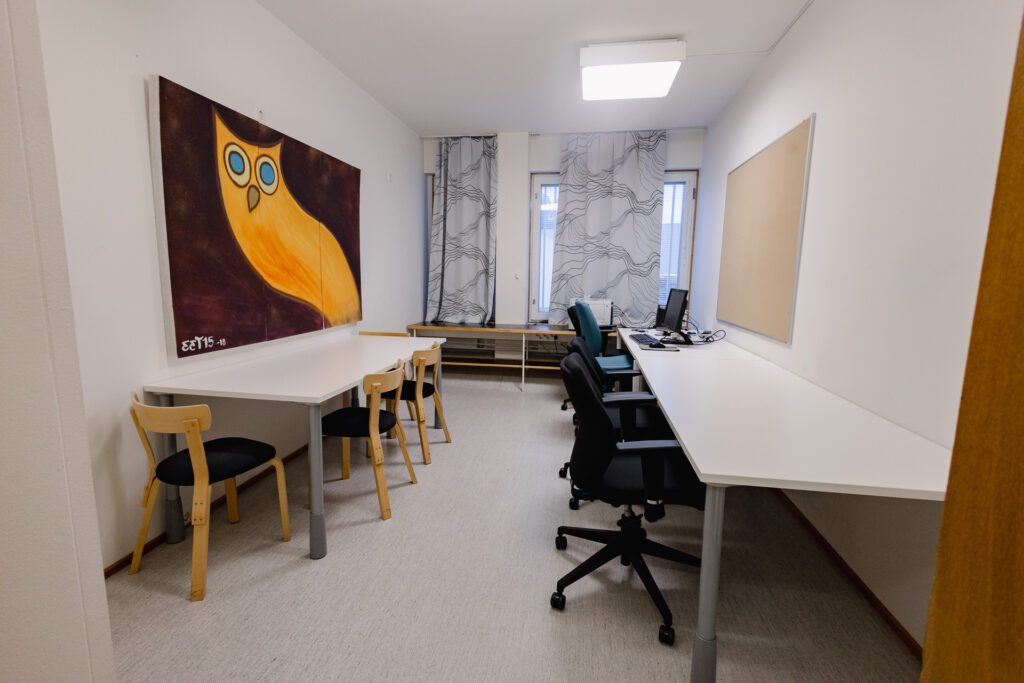 Huone, jossa kaksi pöytää ja tuoleja